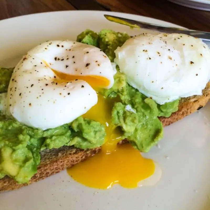 2 Eggs over guacamole toast with side at Edison Lunch Box