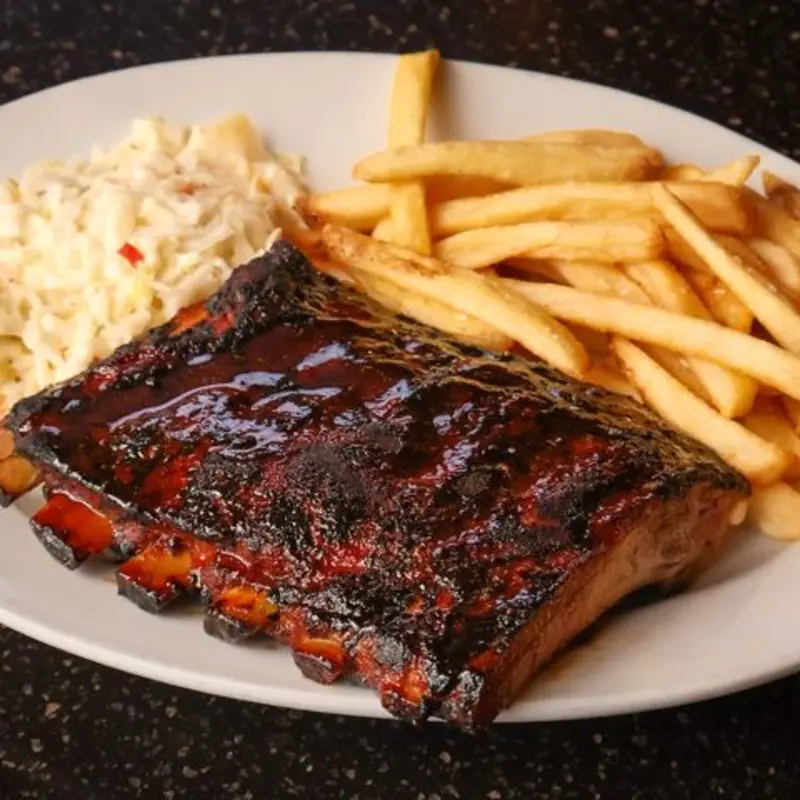 half-rack succulent pork ribs, slow-braised for ultimate tenderness and slathered with a sticky, sweet and tangy BBQ sauce, paired with fries and coleslaw at The Distillery - Mt. Hope | Toast