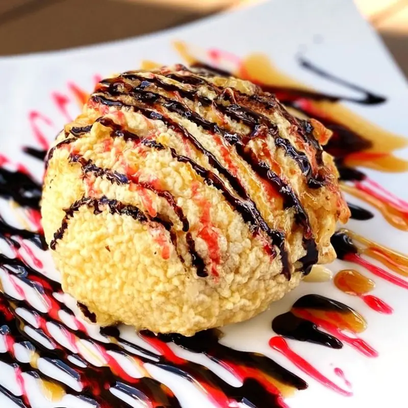 Deep fried ice cream drizzled with chocolate. Drizzled with strawberry and caramel syrup.