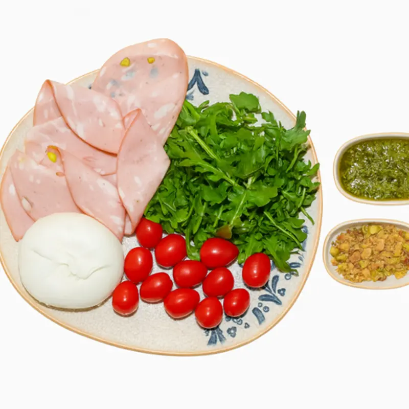 Mortadella and burrata duet with tomatoes, pesto sauce, and pistachios